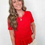 Woman wearing a red top with a white background