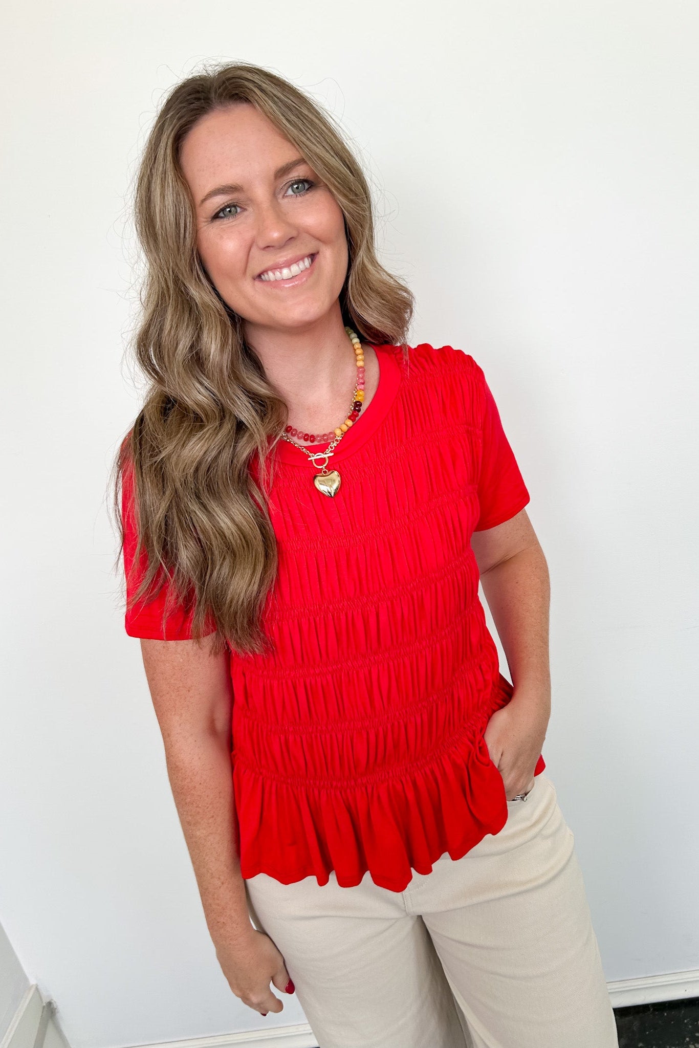 Woman wearing a red top with a white background