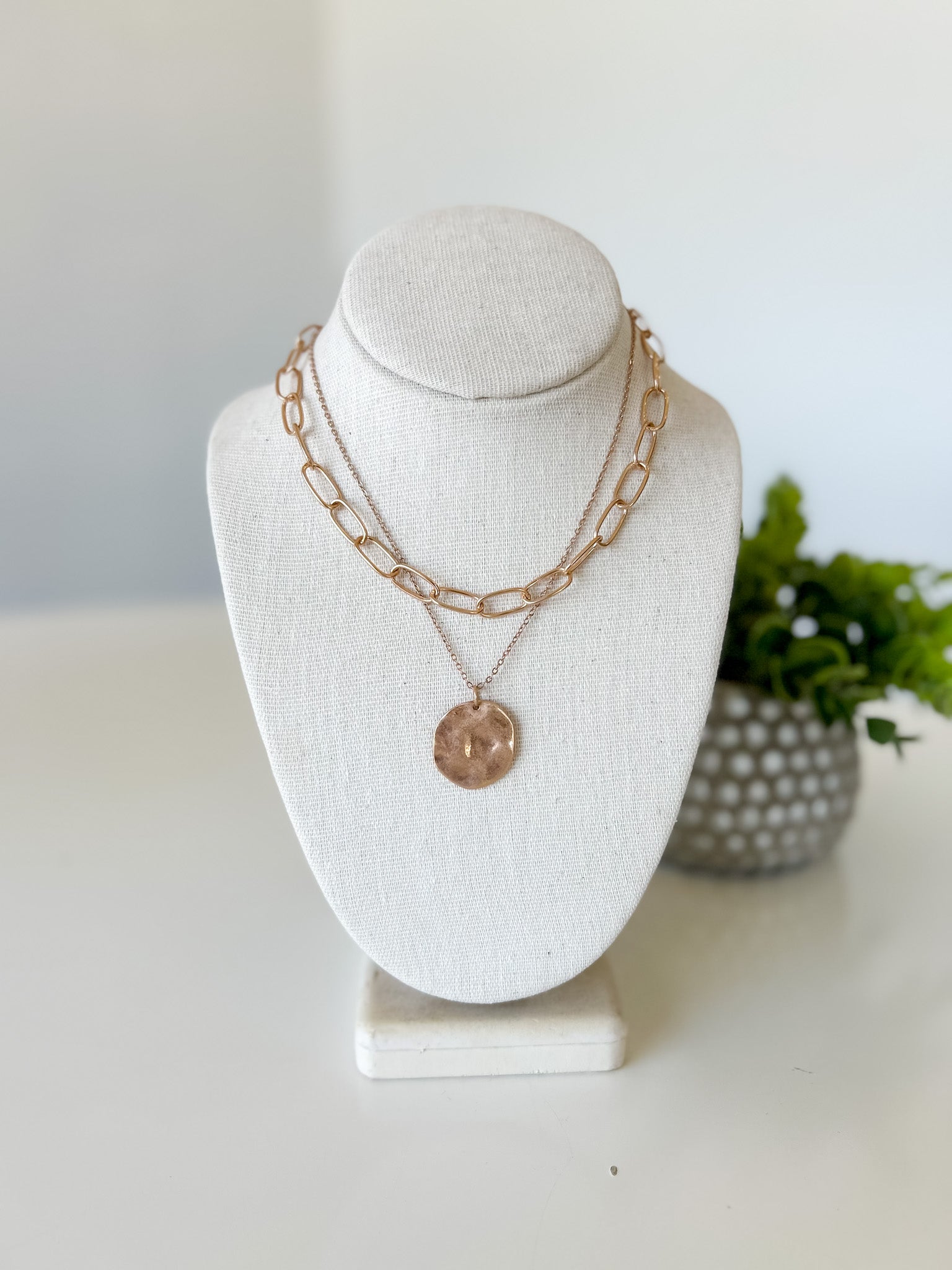 Necklace on a white bust with a blurred background