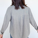 Person wearing a black and white striped shirt with a white background