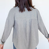 Person wearing a black and white striped shirt with a white background