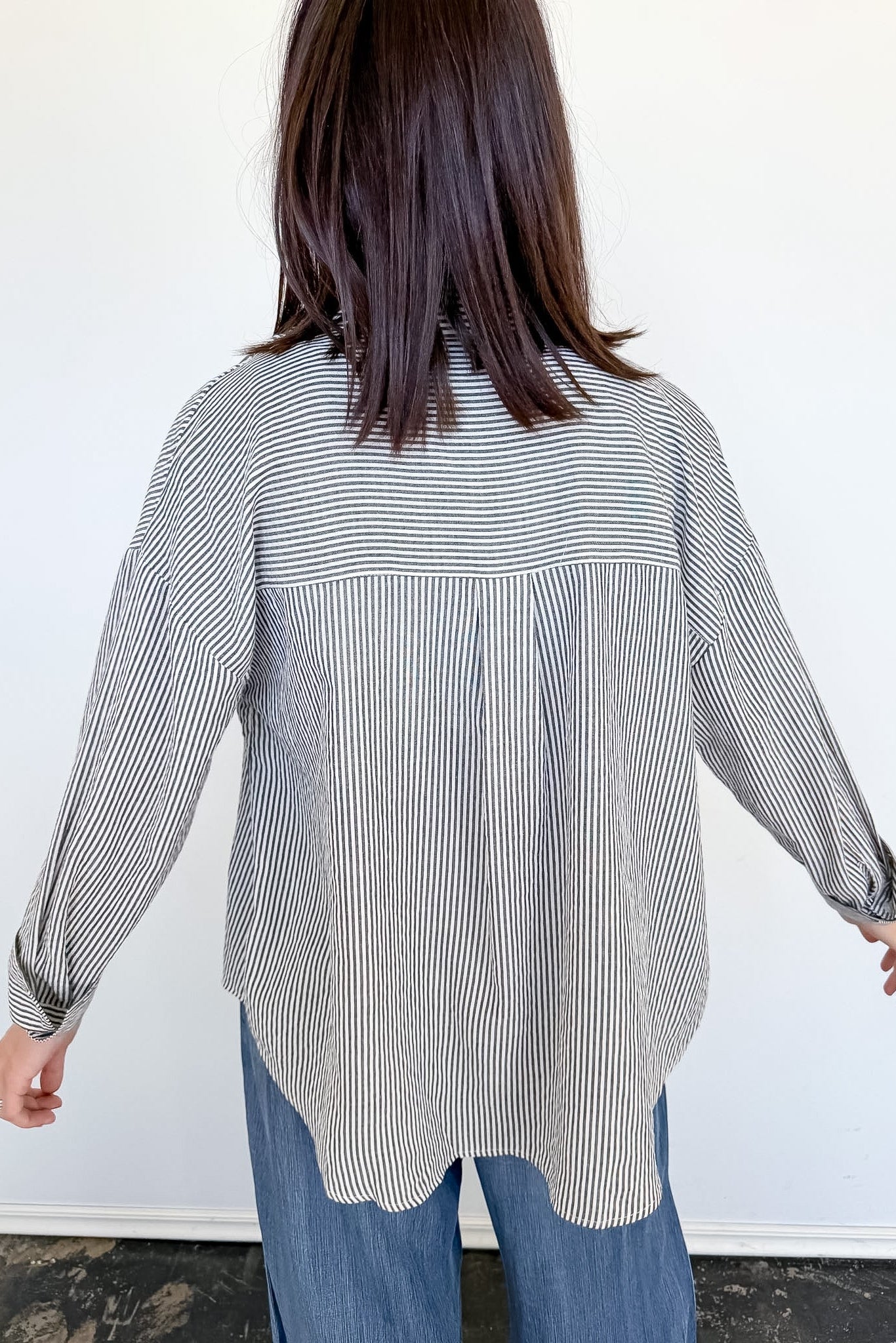 Person wearing a black and white striped shirt with a white background