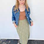 Photo of model wearing a green & white patterned midi skirt