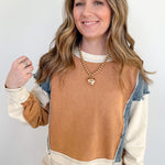 Woman wearing a brown and beige sweater with a denim collar against a white background