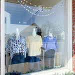 Mannequins in a store window display with clothing and a 'Zara' sign.