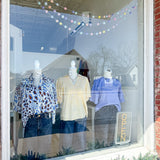 Mannequins in a store window display with clothing and a 'Zara' sign.