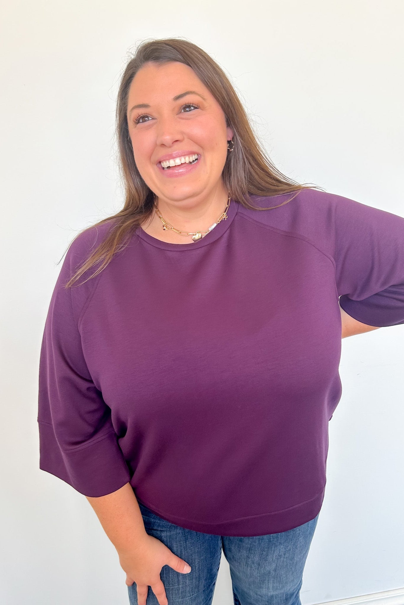 Woman wearing a purple sweater against a white background