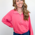 Woman wearing a pink pullover with a zipper on a white background