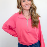 Woman wearing a pink pullover with a zipper on a white background