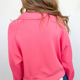 Person wearing a pink sweatshirt and blue jeans against a white background