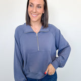 Woman wearing a blue pullover with a zipper on a white background