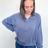 Woman wearing a blue pullover with a zipper on a white background