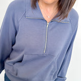 Woman wearing a blue pullover with a zipper on a white background