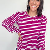 Woman wearing a pink and white striped long-sleeve shirt against a white background