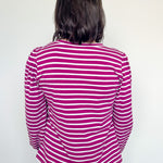 Person wearing a pink and white striped shirt against a white background