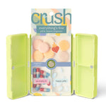 Green pill box with colorful pills and 'crush' packaging on a white background