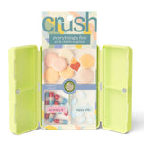 Green pill box with colorful pills and 'crush' packaging on a white background