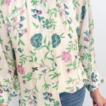 Person wearing a floral blouse with a white background