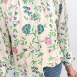 Person wearing a floral blouse with a white background