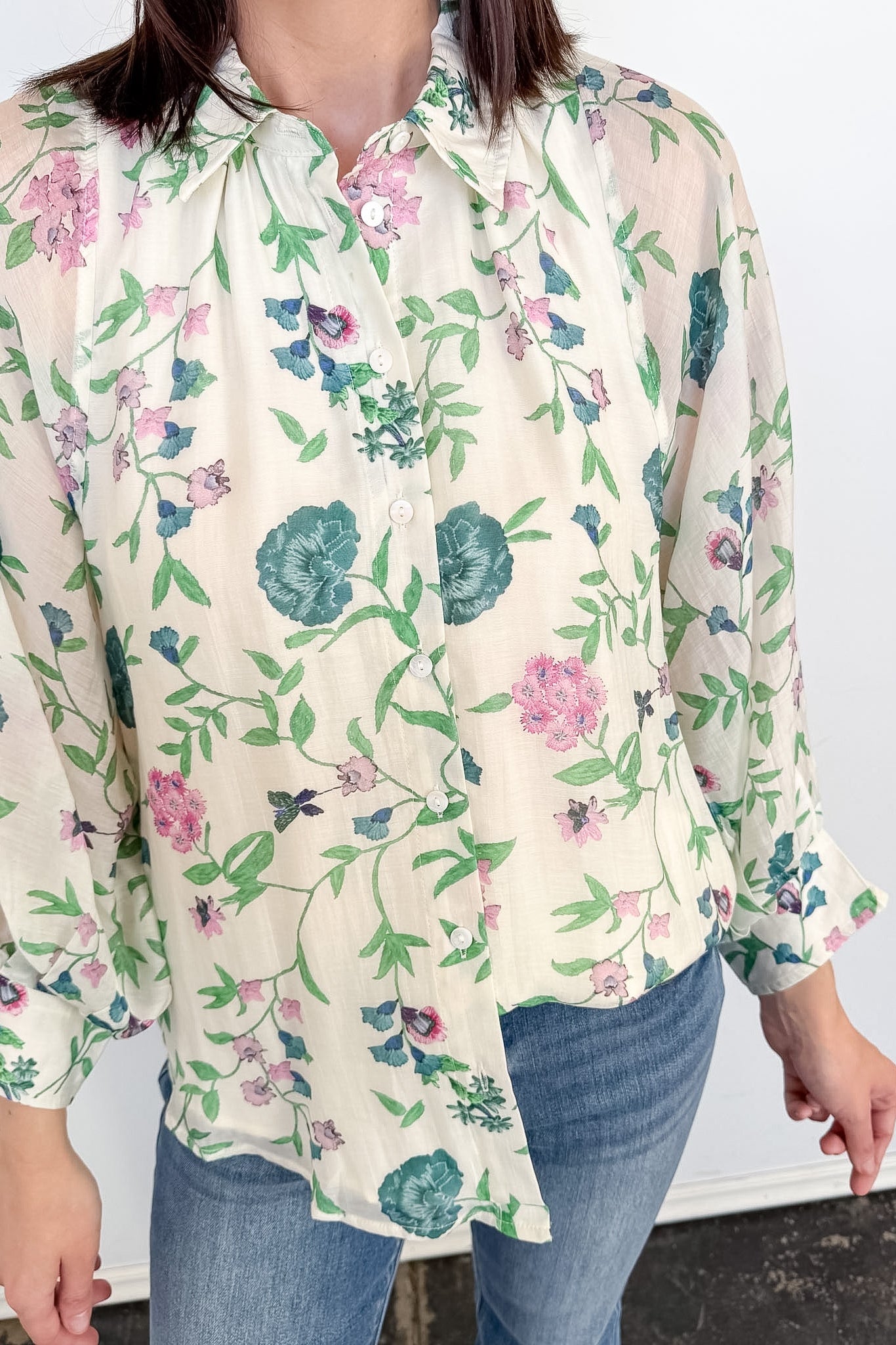 Person wearing a floral blouse with a white background