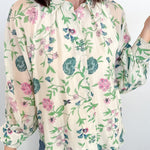 Woman wearing a floral blouse with a plain background