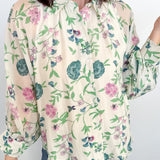Woman wearing a floral blouse with a plain background