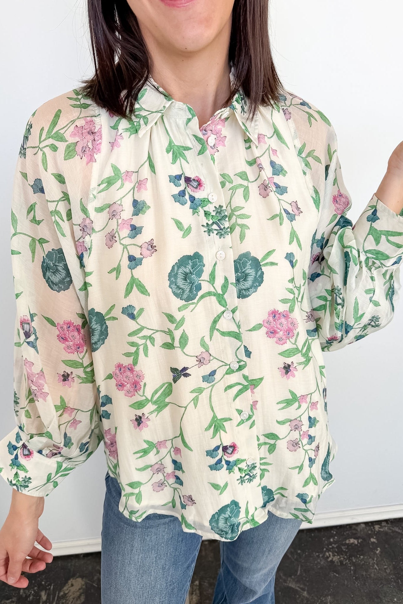 Woman wearing a floral blouse with a plain background
