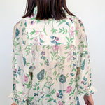 Person wearing a floral blouse with a white background