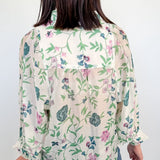 Person wearing a floral blouse with a white background