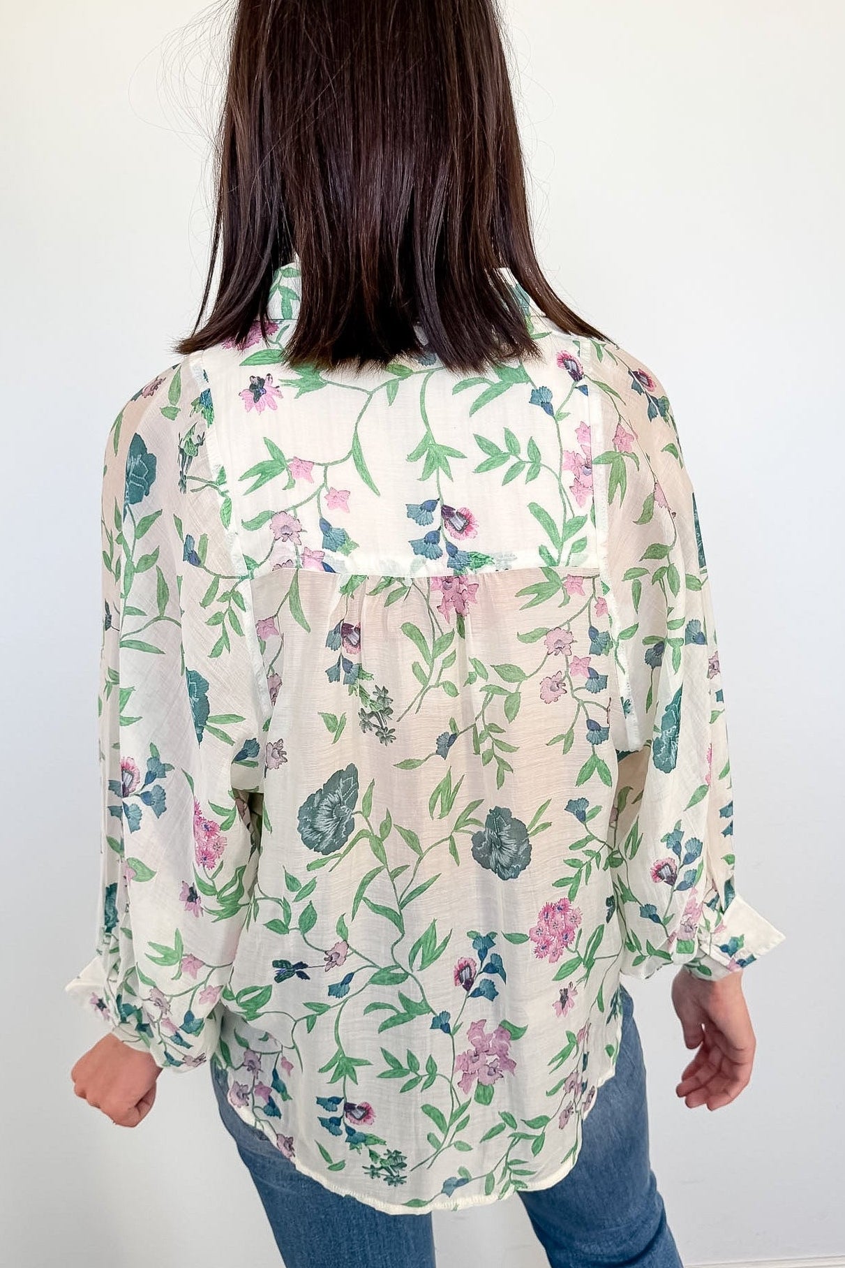 Person wearing a floral blouse with a white background