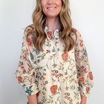 Woman wearing a floral blouse with a plain background