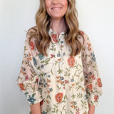 Woman wearing a floral blouse with a plain background