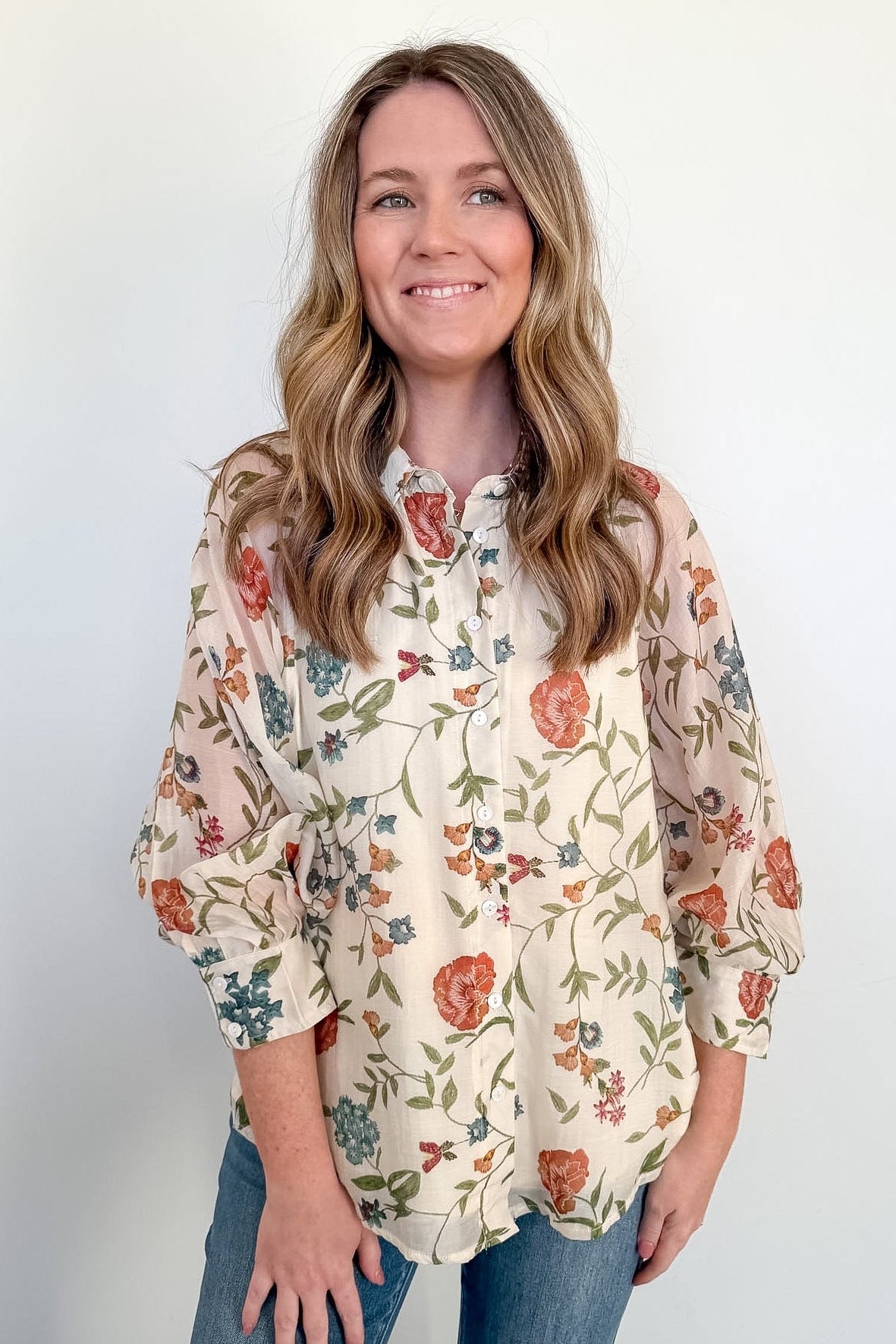 Woman wearing a floral blouse with a plain background