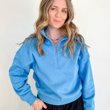 Woman wearing a blue pullover with a white background