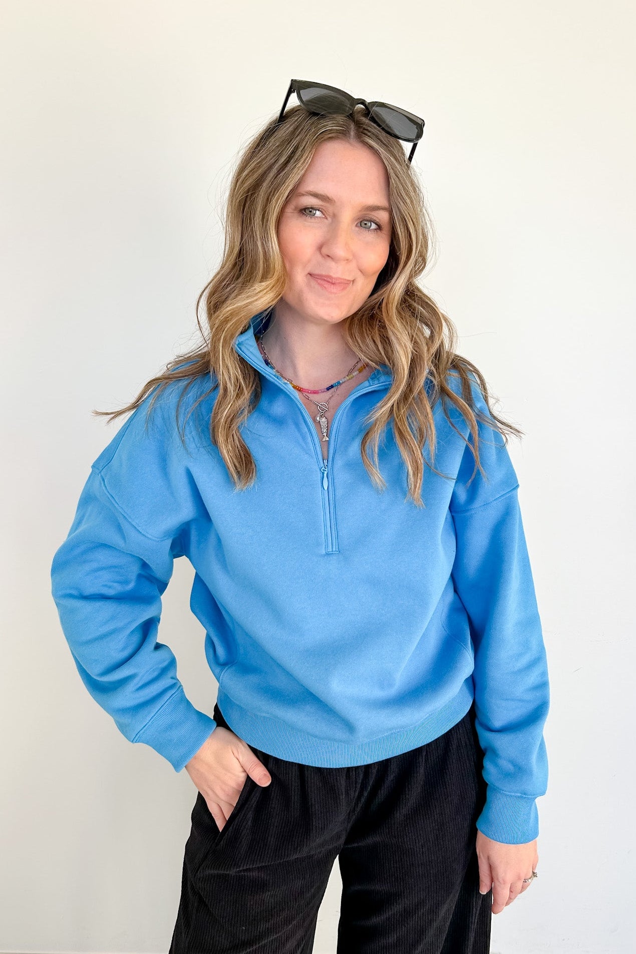 Woman wearing a blue pullover with a white background