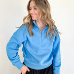 Woman wearing a blue pullover with a white background