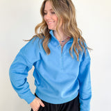 Woman wearing a blue pullover with a white background