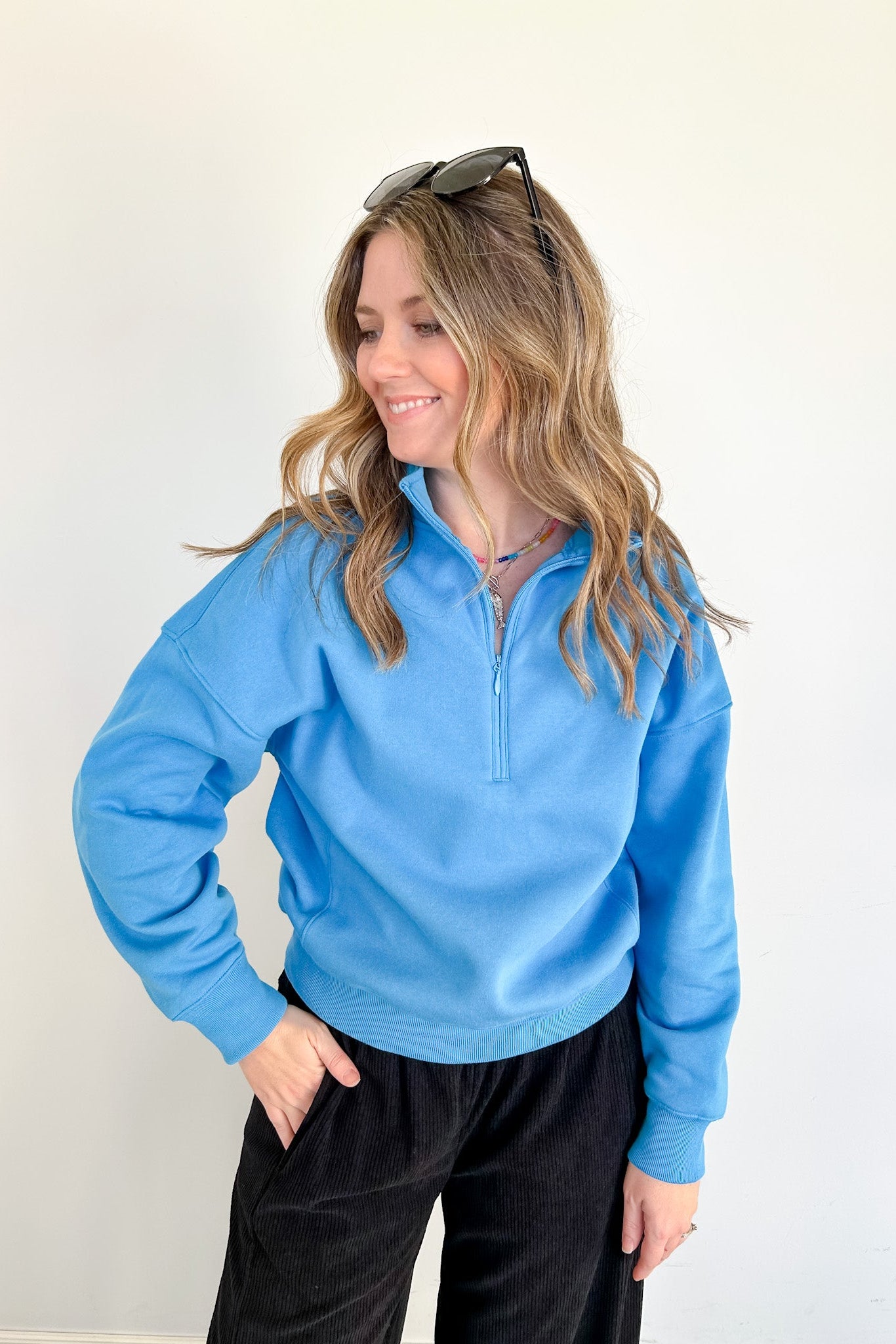 Woman wearing a blue pullover with a white background