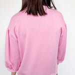 Person wearing a pink sweatshirt with a white background
