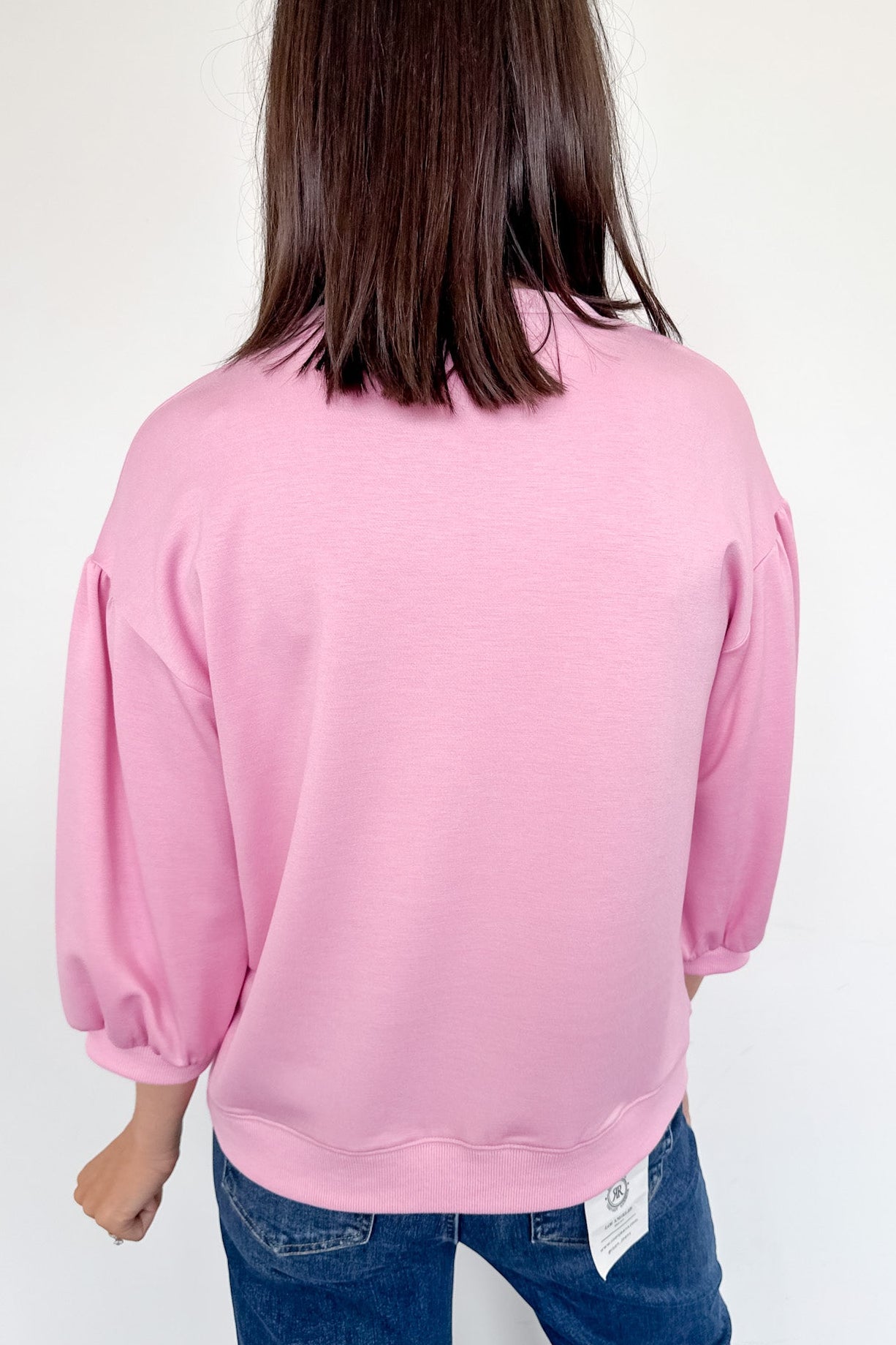 Person wearing a pink sweatshirt with a white background