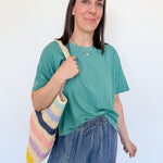 Woman holding a colorful bag against a white background