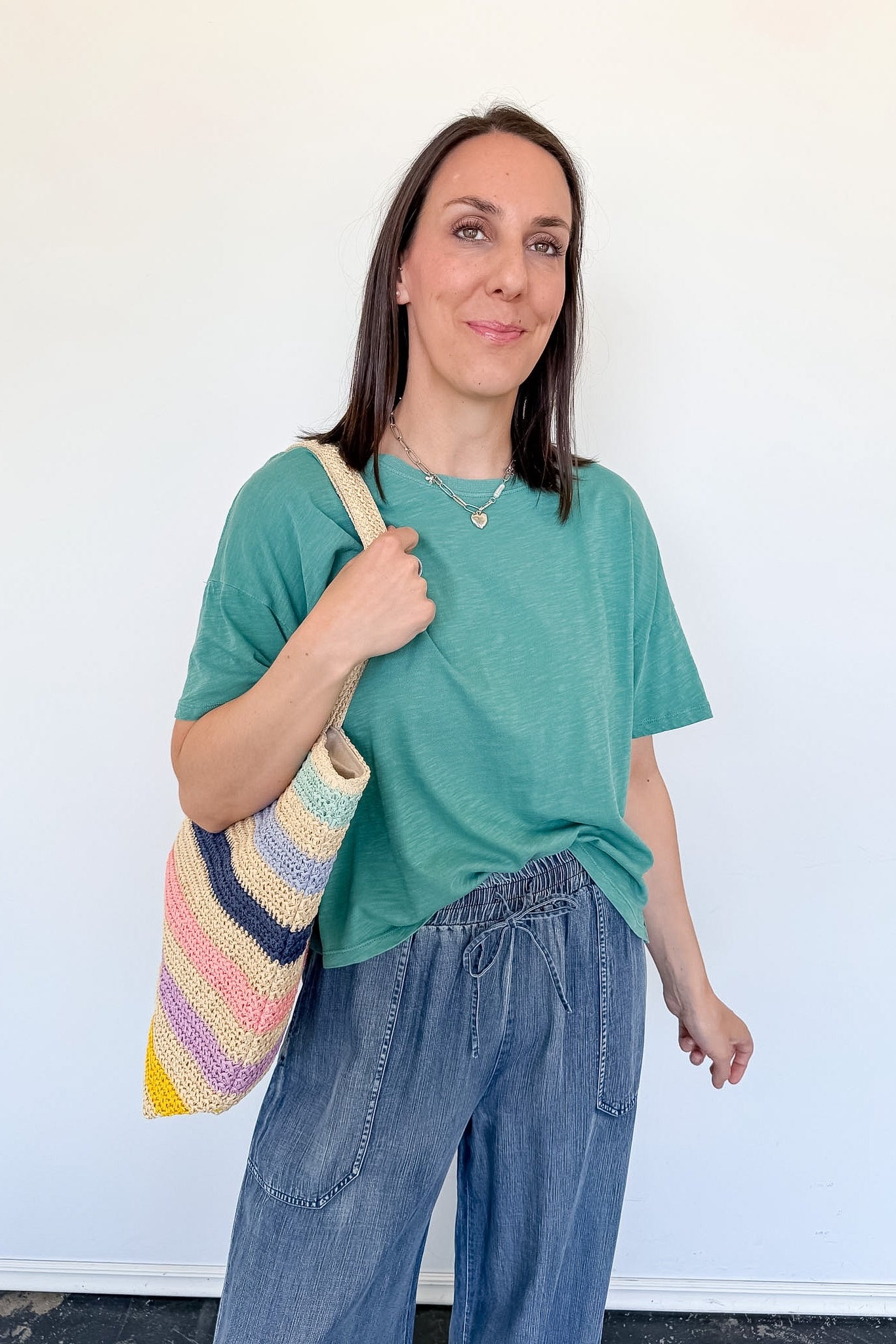 Woman holding a colorful bag against a white background
