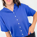 Woman wearing a blue short-sleeve cardigan with a white background