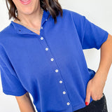 Woman wearing a blue short-sleeve cardigan with a white background