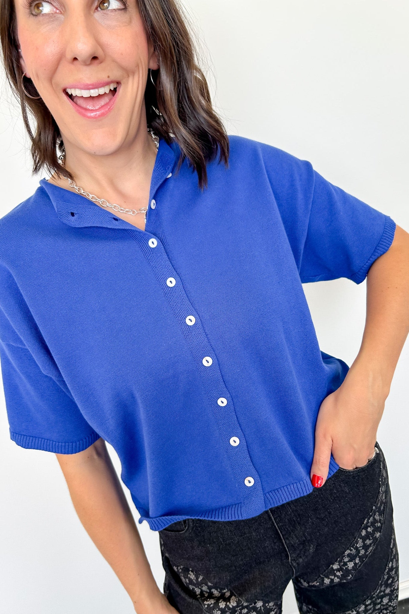 Woman wearing a blue short-sleeve cardigan with a white background