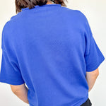 Person wearing a blue sweater against a white background