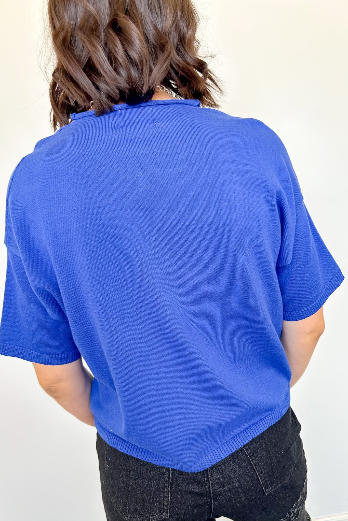 Person wearing a blue sweater against a white background