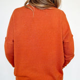 Person wearing an orange sweater on a white background