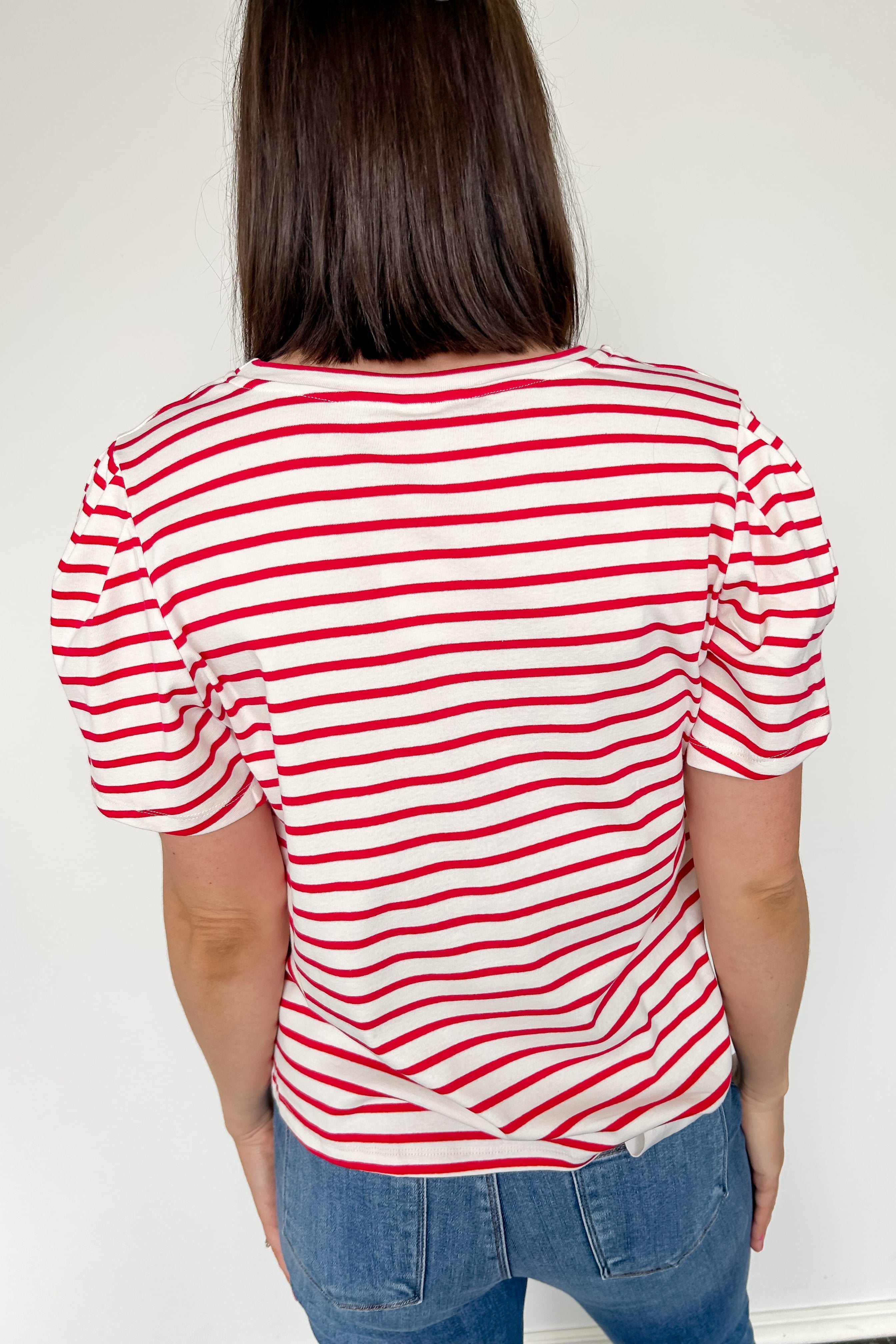 Red and white horizontal striped top. High round neckline with short sleeves. Regular fit. Slight puff in the sleeves.