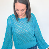 Woman wearing a blue knitted sweater against a white background